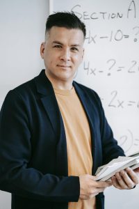 Photo Of Man Standing In Front Of White Board