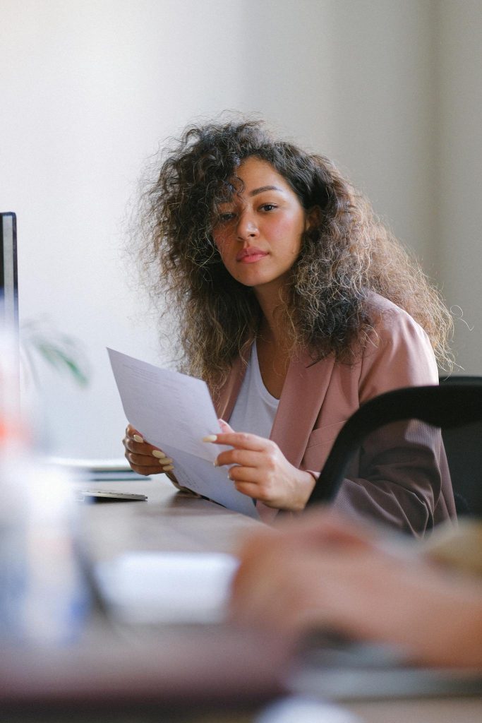 Thoughtful woman with documents working in office
